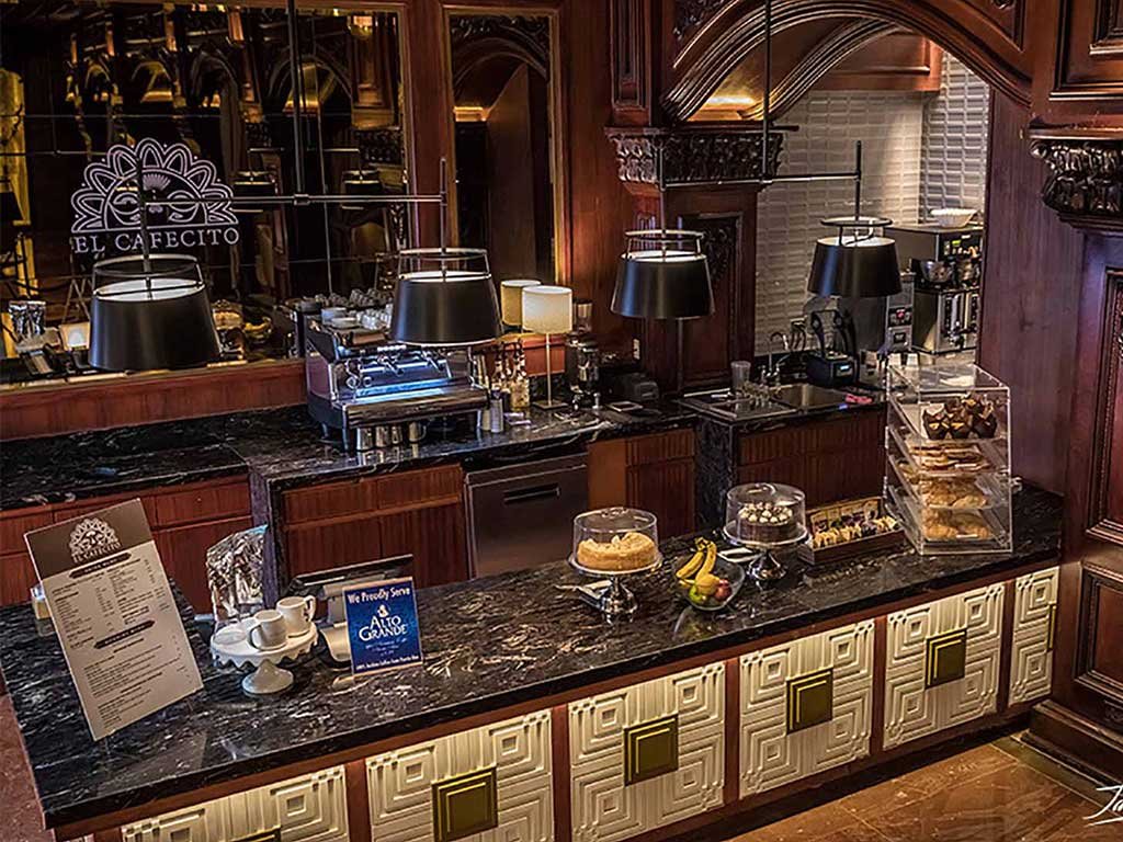 El Cafecito coffee bar in a wood-panelled hotel lobby with the logo on the mirror