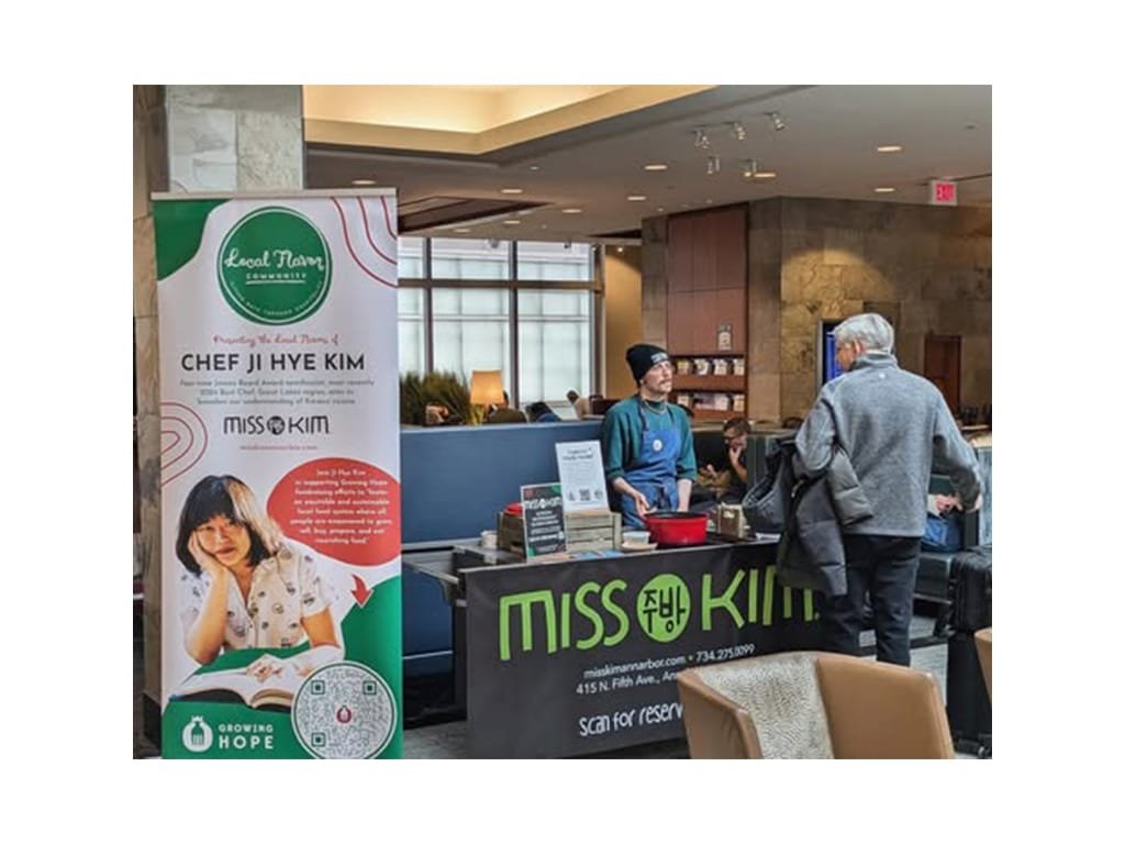 Local Flavor banner on display beside a Miss Kim tasting table in a Delta Sky Club lounge