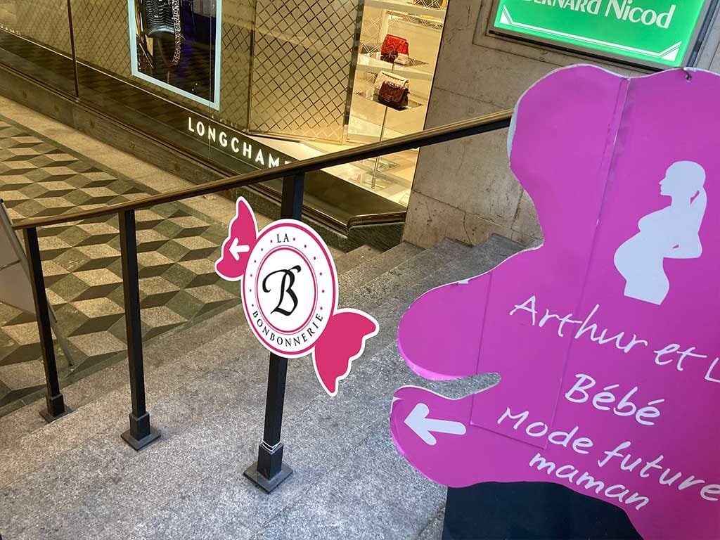 Candy-shaped La Bonbonnerie wayfinding sign in a shopping arcade